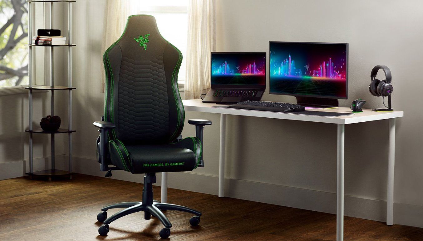 Silla gamer razer y un escriotrio con mouse monitor y notebook